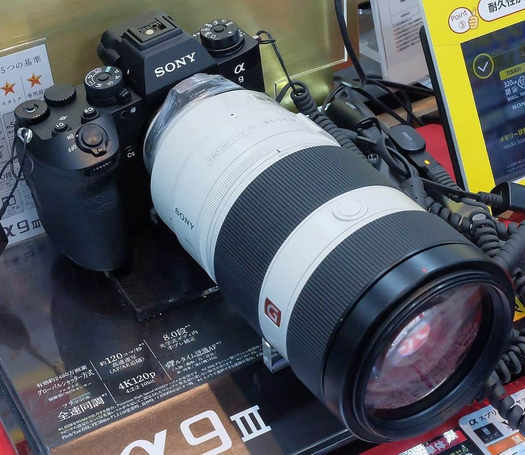 Sony a9 III med vitt teleobjektiv i en butiksmonter med japanska skyltar