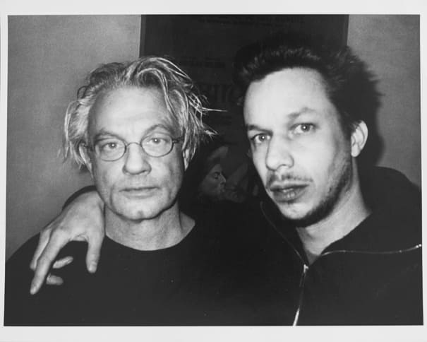 Svartvitt foto där JH Engström står tätt intill Anders Petersen, som har glasögon och ljust hår