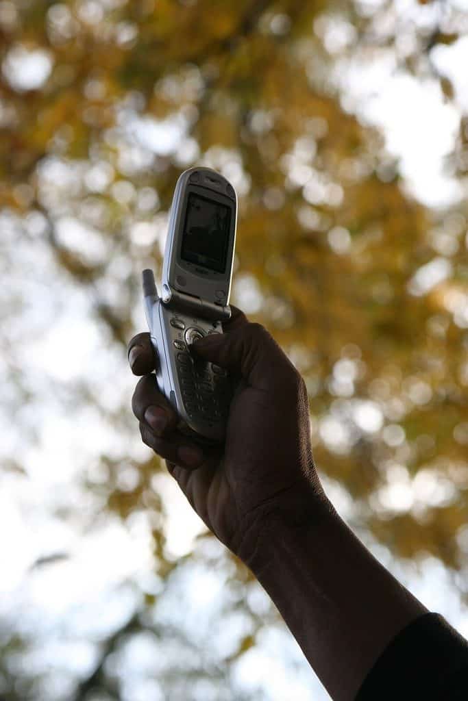 Person som fotograferar med mobiltelefonen hållen på utsträckt arm framför sig, med motivet synligt på skärmen.