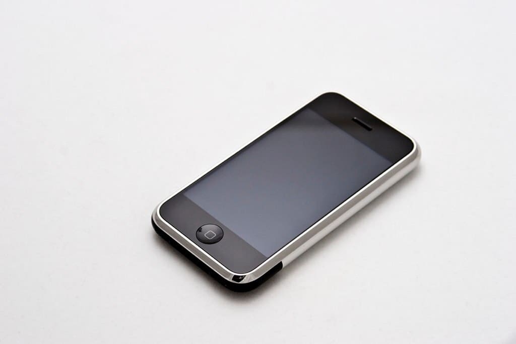 Den första iPhone liggande med skärmen uppåt, sedd snett ovanifrån.