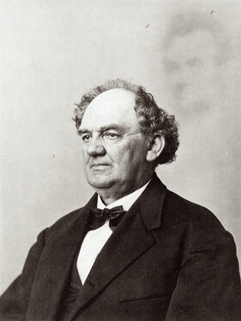 Porträtt av P.T. Barnum sittande i kostym, med en blek och genomskinlig bild av Abraham Lincoln bakom sig, ett falskt andefotografi från 1869.