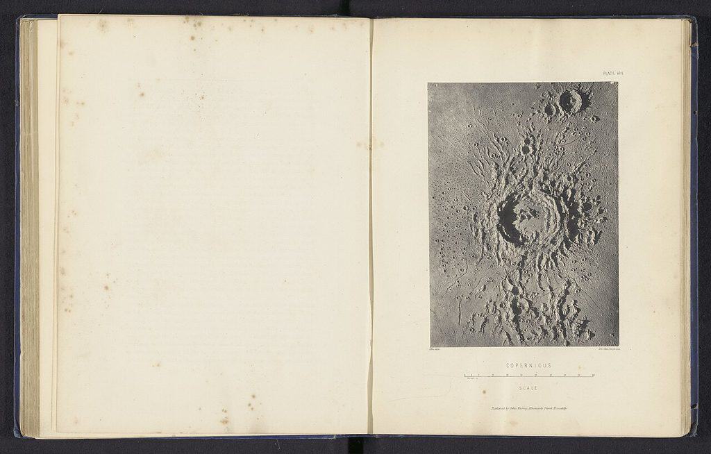 Uppslagen bok från 1870-talet med ett fotografi av en gipsmodell av månkratern Copernicus, med skarpa skuggor från kraterväggarna.