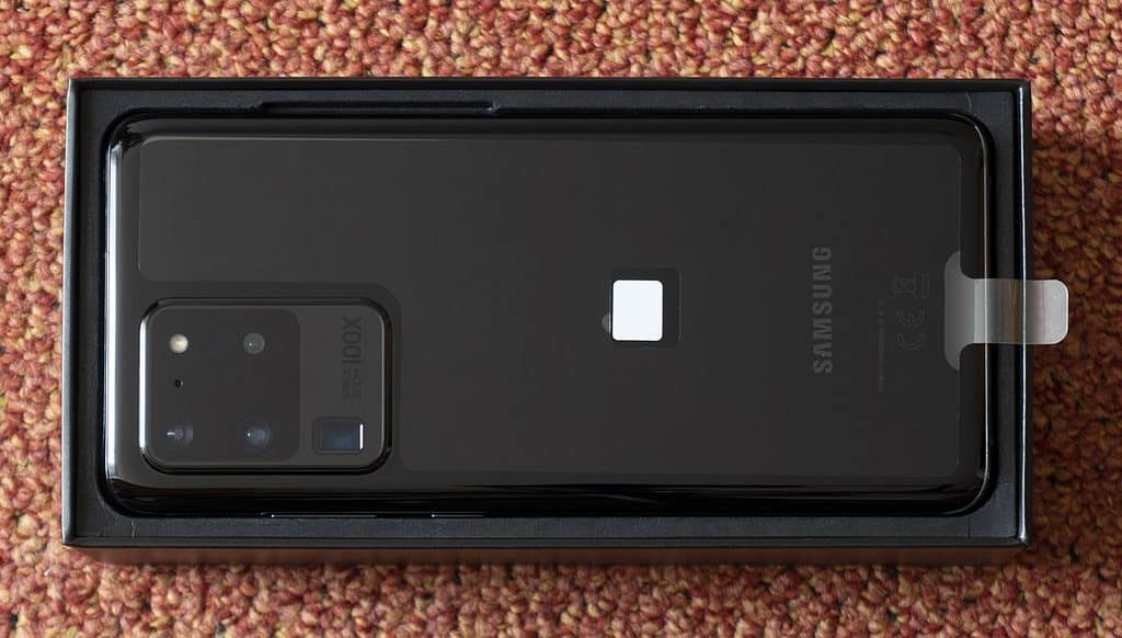 Baksidan på en svart Samsung Galaxy S20 Ultra i sin kartong, med ett stort rektangulärt kameraparti i övre vänstra hörnet.