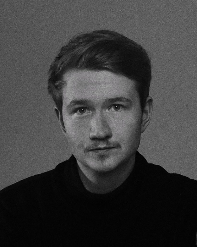 Joakim Möller i svart tröja mot grå bakgrund, med blicken rakt in i kameran