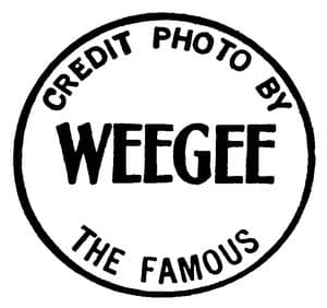 En rund stämpel i svart på vit botten. Längs den övre kanten står Credit photo by, i mitten Weegee i stora fetstilta versaler och längs den nedre kanten The famous.